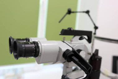 Göz muayenesinde kullanılan küçük lamba biyomikroskobu, modern bir muayenehaneye yerleştirilmiş, optik cihazın yakın görüntüsü.