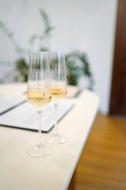 İçi köpüklü şarapla dolu iki zarif şampanya kadehi düğün kadehi için hazır bekliyor..