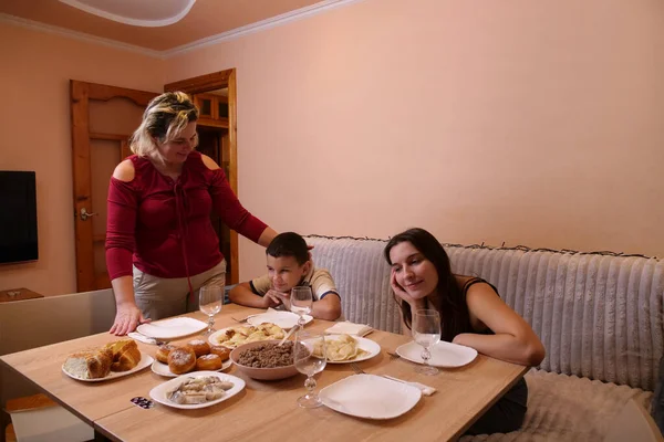 Aile masada, anne oğlunu okşuyor, sıcak bir festival havası var..