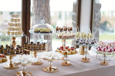 Muhtelif pastalar, badem kurabiyeleri, kremalar ve tatlılarla dolu büyük bir şenlik masası.