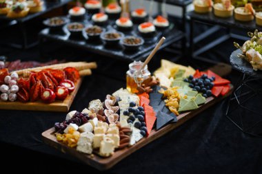 Tahtada ekmek çubuklarıyla pişirilmiş et ve sosis tabağı..