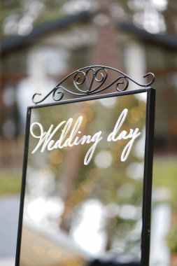 Ayna işareti ve metal tezgahta düğün günü yazıları, Bokeh ışıkları ile düğün süslemeleri.