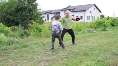 Çocuk boks antrenmanında kaçarken yetişkin koçu yumruk gösterisi yapıyor..