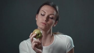 Bir elma yemek güzel ve genç birbayan. İzole siyah. Portre.