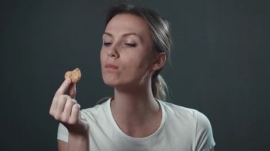Genç kadın Nuggets yeme. İzole siyah. Portre.