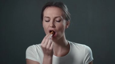 Genç kadın hızlı yemek yeme. İzole siyah. Portre.