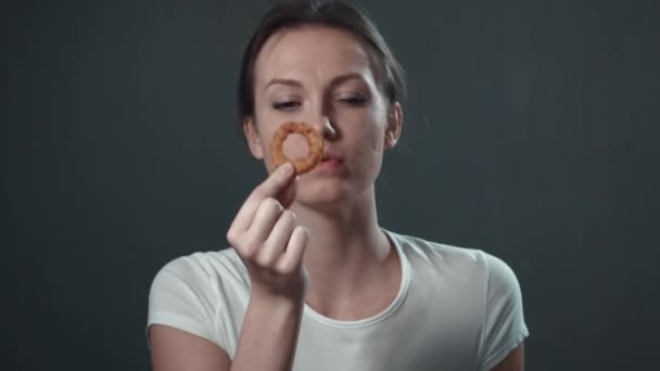 Dziewczynka jedzenie krążki cebuli. Czarny na białym tle. Portret. — Wideo stockowe