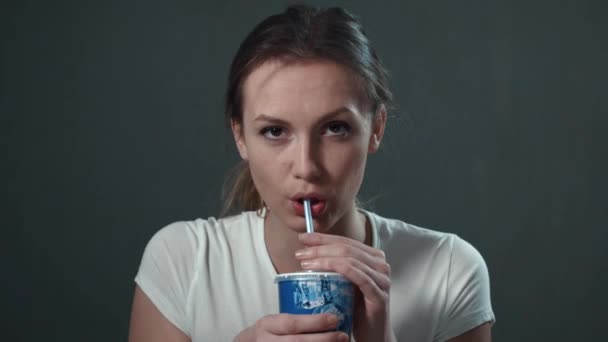 若い女性は、コーラを飲みます。孤立したブラック。肖像画. — ストック動画