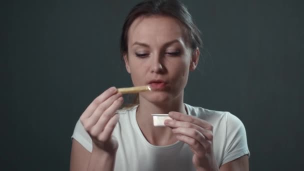 Γλυκό κορίτσι τρώει πατάτες τηγανιτές. Απομονωμένη μαύρο. Πορτρέτο. — Αρχείο Βίντεο