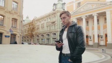 Genç acımasız adam yabancı bir Avrupa şehri dolaşıyor.