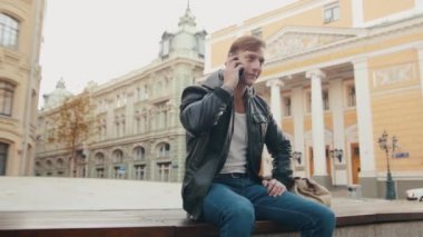 Avrupa bir şehirde telefonda konuşan genç acımasız adam.