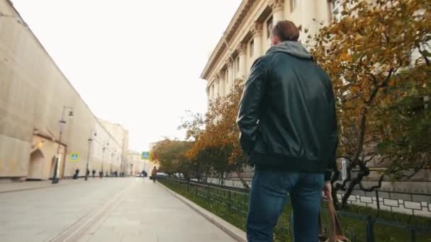 Young brutal man walks through an empty European city at dawn. — Stock Video