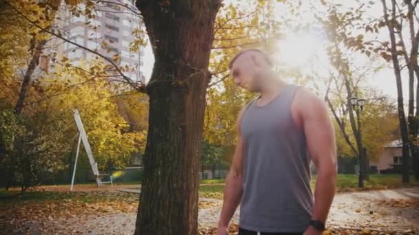 En ung man sträcker nacken före träning, vrida den — Stockvideo