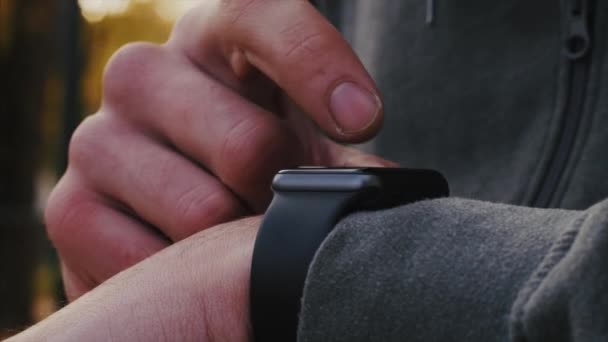 Young athlete uses smart watch with his finger — Stock Video