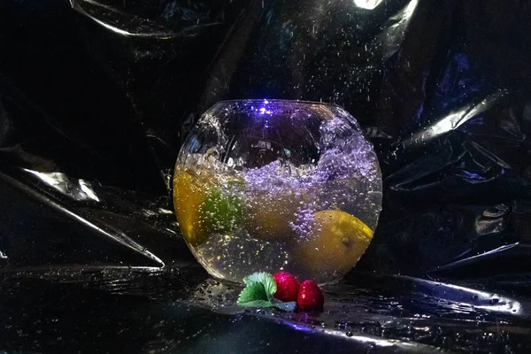 A large aquarium filled with mineral water, fruit thrown into it. It was a splash.