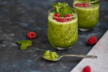 Diyet içeceği, smoothie. Yeşil renk. Vücut temizliği. Diyet. Salatalık, elma, limon, zencefil, avokado. Bir bardak ahududu da. Kaşıkta yemek. Sağlıklı beslenme. Hafif kahvaltı. 