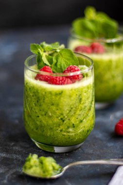Diyet içeceği, smoothie. Yeşil renk. Vücut temizliği. Diyet. Salatalık, elma, limon, zencefil, avokado. Bir bardak ahududu da. Kaşıkta yemek. Sağlıklı beslenme. Hafif kahvaltı. 