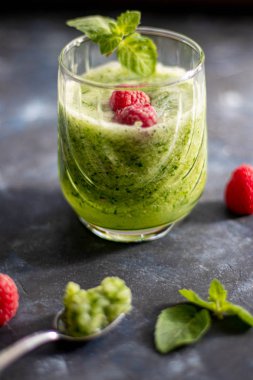 Diyet içeceği, smoothie. Yeşil renk. Vücut temizliği. Diyet. Salatalık, elma, limon, zencefil, avokado. Bir bardak ahududu da. Kaşıkta yemek. Sağlıklı beslenme. Hafif kahvaltı. 