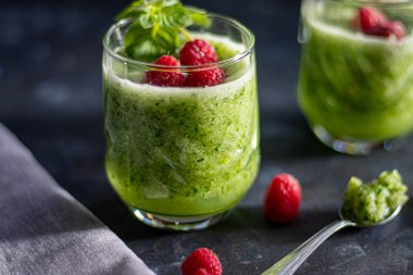 Diyet içeceği, smoothie. Yeşil renk. Vücut temizliği. Diyet. Salatalık, elma, limon, zencefil, avokado. Bir bardak ahududu da. Kaşıkta yemek. Sağlıklı beslenme. Hafif kahvaltı. 