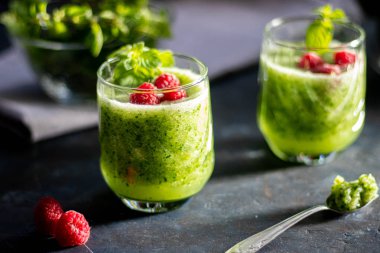 Diyet içeceği, smoothie. Yeşil renk. Vücut temizliği. Diyet. Salatalık, elma, limon, zencefil, avokado. Bir bardak ahududu da. Kaşıkta yemek. Sağlıklı beslenme. Hafif kahvaltı. 