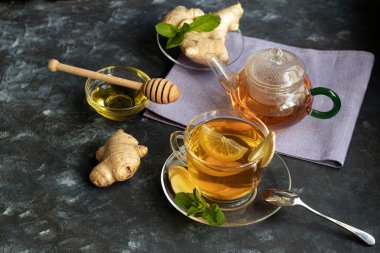 Limonlu zencefil çayı. Kilo kaybını teşvik eder. Soğuk algınlığıiyileştirir. Yakında taze bir kök ve kireç yeşili yatıyor. 