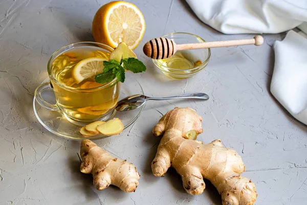 Limonlu zencefil çayı. Kilo kaybını teşvik eder. Soğuk algınlığıiyileştirir. Yakında taze bir kök ve kireç yeşili yatıyor. 