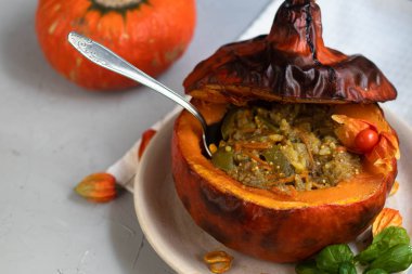 Fırında kabak pirinç ile sebze güveç ile doldurulmuş. Yakınlarda physalis meyveleri vardır ve arka planda taze bir portakal tavernası bulunmaktadır. sağlıklı yaşam tarzı. Doğru beslenme. Diyet. 