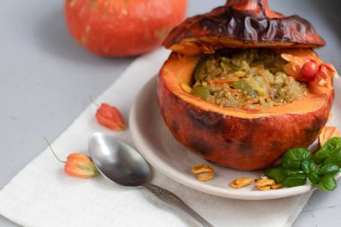 Fırında kabak pirinç ile sebze güveç ile doldurulmuş. Yakınlarda physalis meyveleri vardır ve arka planda taze bir portakal tavernası bulunmaktadır. sağlıklı yaşam tarzı. Doğru beslenme. Diyet. 