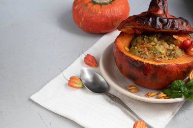 Fırında kabak pirinç ile sebze güveç ile doldurulmuş. Yakınlarda physalis meyveleri vardır ve arka planda taze bir portakal tavernası bulunmaktadır. sağlıklı yaşam tarzı. Doğru beslenme. Diyet. 