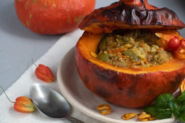 Fırında kabak pirinç ile sebze güveç ile doldurulmuş. Yakınlarda physalis meyveleri vardır ve arka planda taze bir portakal tavernası bulunmaktadır. sağlıklı yaşam tarzı. Doğru beslenme. Diyet. 