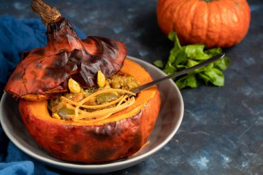 Fırında kabak pirinç ile sebze güveç ile doldurulmuş. Yakınlarda physalis meyveleri vardır ve arka planda taze bir portakal tavernası bulunmaktadır. sağlıklı yaşam tarzı. Doğru beslenme. Diyet. 