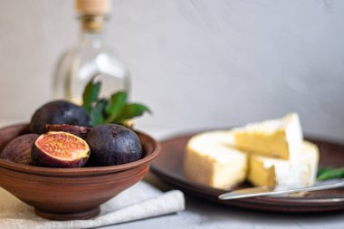 Olgun, güzel, mor incirler. Tatlı ve sulu. Akdeniz meyvesi çok sağlıklıdır. Tabakta Brie peyniri var. Açık gri arka plan kopyalama boşluğunda boş bir yer var. Vejetaryenler için yiyecek.. 