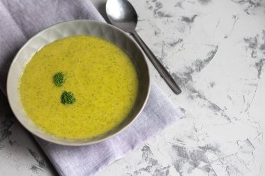 Yeşil brokoli kremalı çorba, chia tohumu, kırmızı soğan, yeşil biber, kiraz domatesleri ve kızarmış ekmekler açık gri, taş zemin üzerinde. Sağlıklı beslenme konsepti. Yukarıdan bak. Boşluğu kopyala.