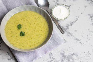 Yeşil brokoli kremalı çorba, chia tohumu, kırmızı soğan, yeşil biber, kiraz domatesleri ve kızarmış ekmekler açık gri, taş zemin üzerinde. Sağlıklı beslenme konsepti. Yukarıdan bak. Boşluğu kopyala.