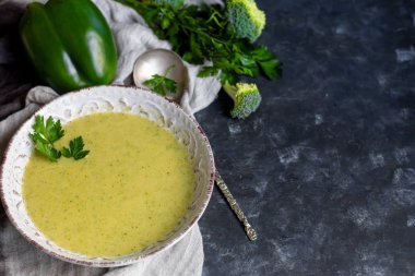 Yeşil brokoli kremalı çorba, chia tohumu, kırmızı soğan, yeşil biber, kiraz domatesleri ve kızarmış ekmekler açık gri, taş zemin üzerinde. Sağlıklı beslenme konsepti. Yukarıdan bak. Boşluğu kopyala.