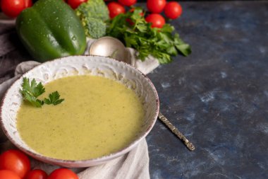 Yeşil brokoli kremalı çorba, chia tohumu, kırmızı soğan, yeşil biber, kiraz domatesleri ve kızarmış ekmekler açık gri, taş zemin üzerinde. Sağlıklı beslenme konsepti. Yukarıdan bak. Boşluğu kopyala.