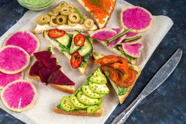 Sandviçler üçgen ve oval. Vejetaryen ve daha fazlası. Avokado, ıspanak ve kremalı yoğurt. Salatalık, şalgam, domates, salam, balyk, kırmızı havyar, ıspanak, yumurta ve zeytin.. 