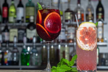 Bir dilim portakal ve greyfurtla yaz kokteyllerini tazeliyorum. Alkolik içki. Bir tutam nane ve buz ile süslenmiş. Barda. Önplan.