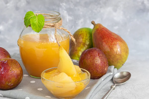 Erik reçeli. Armut dilimleriyle birlikte. Gelecekte kullanılacak ürünlerin satın alınması. Arka planda taze meyveler var. Gri bir arka planda. Boşluğu kopyala