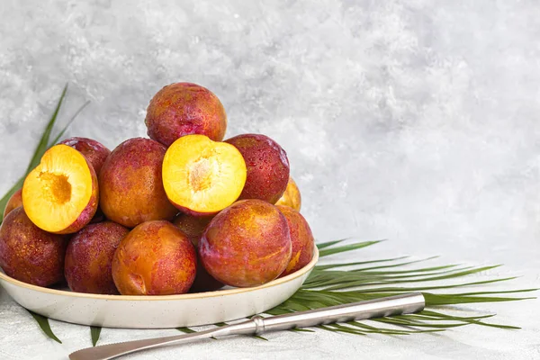 Fresh plums are yellow-red. Juicy and large. Purchase of goods for future use. Vitamins for immunity. On a light background. Copy space