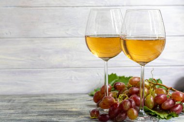 Büyük ve hafif, şarap üzümleri. Maya adı verilen beyaz bir kaplama ile kaplıdır. Bardaklar hafif şarapla doludur. Böğürtlenlere su. Ahşap bir arka planda. Boşluğu kopyala.