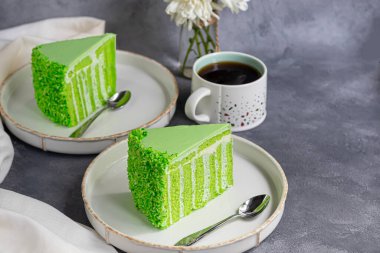 Elmalı bisküvili doğum günü pastası. İki tabak, iki porsiyon ve bir fincan kahve. Gri bir arka planda. Doğum günü, tatiller, şekerler. Boşluğu kopyala.