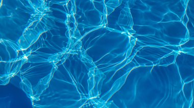 Havuzdaki su mavidir, güneş ışınları tarafından nüfuz edilir. Seçici odaklanma. Sağlıklı bir yaşam tarzı. Çocuklar için Tatil.