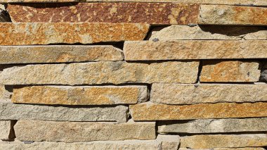 Masonluk duvarda ve yerde. Çeşitli taş dokuları. Çok renkli bir arka plan. Gölgeler.