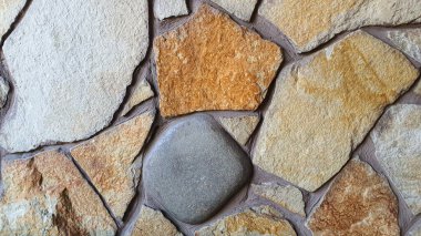 Masonluk duvarda ve yerde. Çeşitli taş dokuları. Çok renkli bir arka plan. Gölgeler.