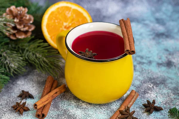 Mulled wine, a warming drink in a cup with spices. Christmas toys. New Year mood. On a light background. Copy space.