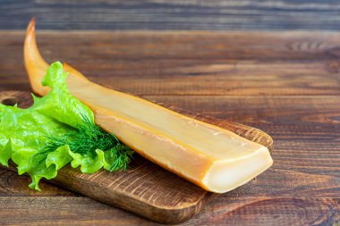 Tütsülenmiş mürekkep balığı leşi. Salata, vişneli domates ve soğanlı ahşap arka planda. Boşluğu kopyala.