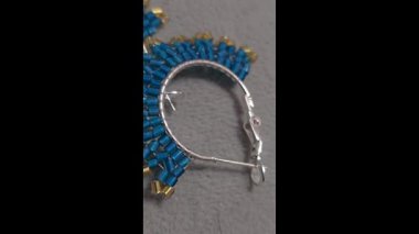 Handmade beaded and glass bead earrings on a light background. Copy space