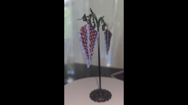 Handmade beaded and glass bead earrings on a light background. Copy space