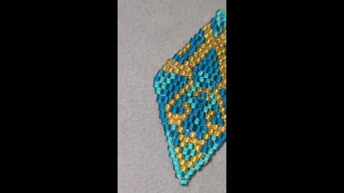 Hafif arka planda el yapımı boncuklu ve cam boncuklu küpeler. Ürün gösterisi. Moda trendleri. Boşluğu kopyala